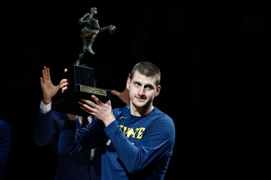 Nikola Jokic posing with the NBA MVP award.