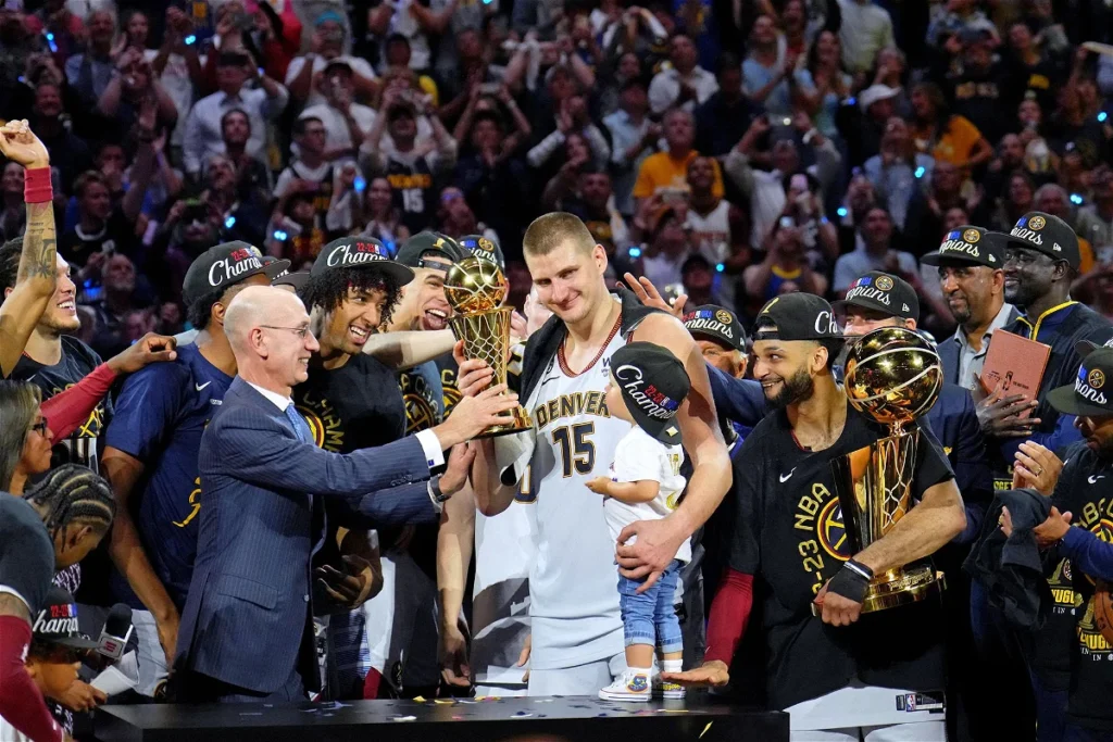 NBA Commissioner Adam Silver giving Jokic the NBA Finals MVP award